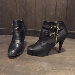 Black leather ankle bootie with gold accents
